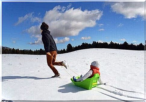 play in snow with toboggan