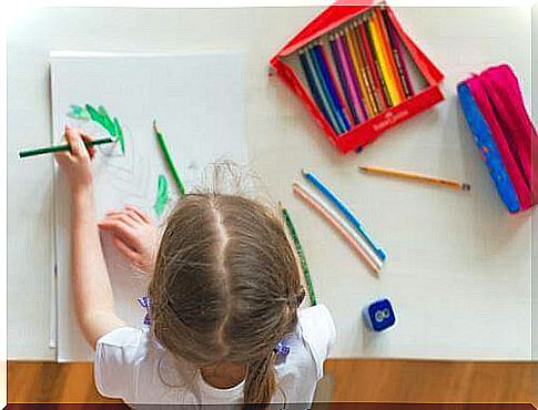 Girl sitting and drawing at her desk.