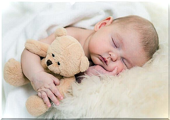 baby sleeping with a teddy bear