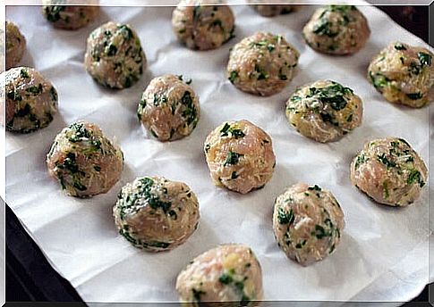 meatballs with spinach on baking sheet