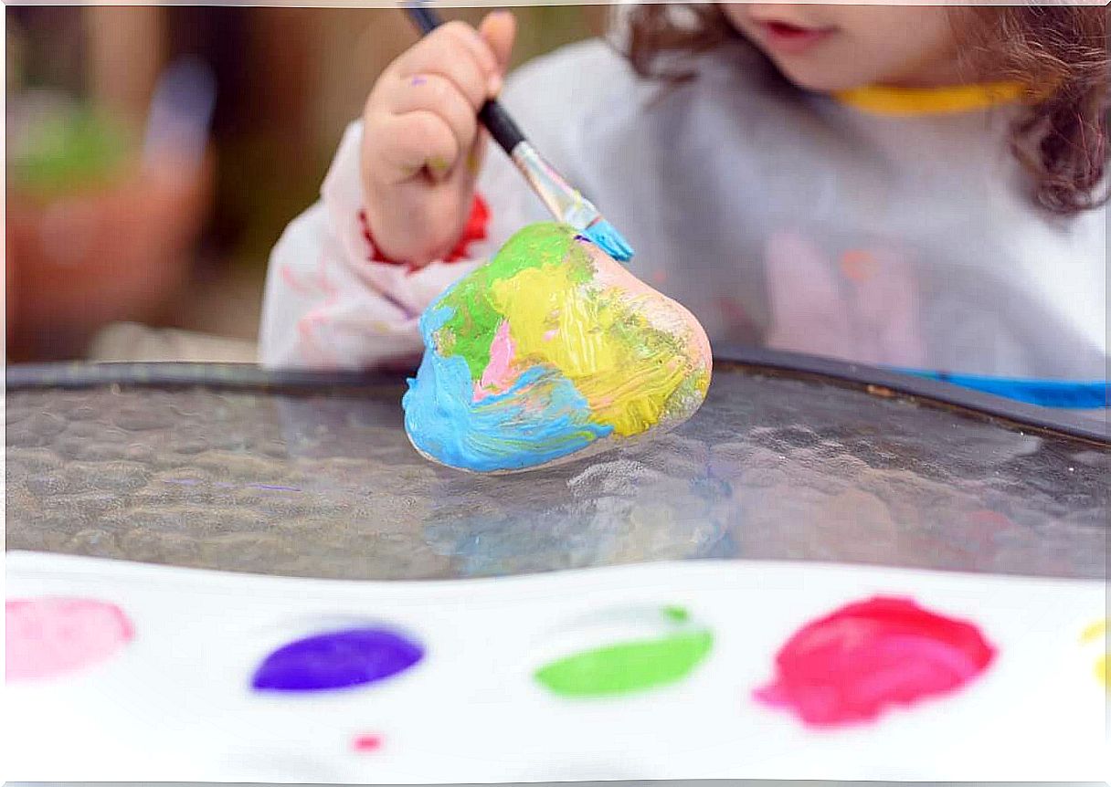 Girl makes painted stones