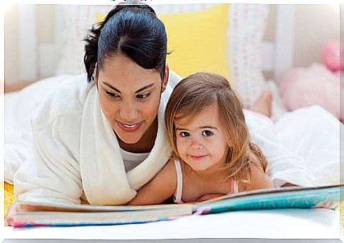 mother and daughter reading in bed