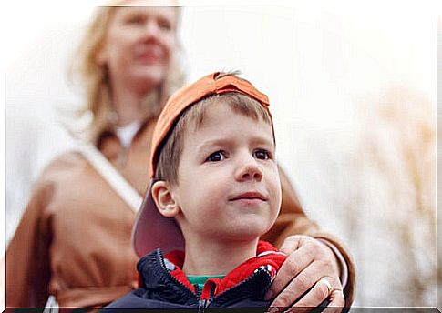 little boy with his mother's hand on his shoulder