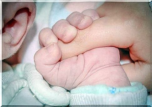 baby holds parent's finger