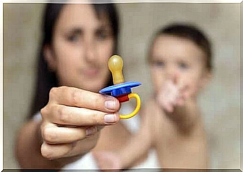 Mother holds her baby's pacifier