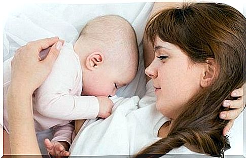 mother lying and breastfeeding her baby