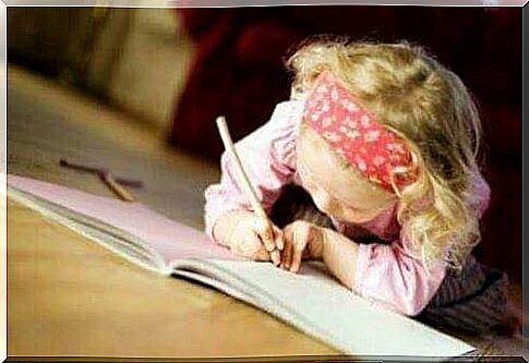 Author children: Little girl lying on the floor and writing in notebook.