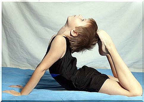 boy touching his head with his toes