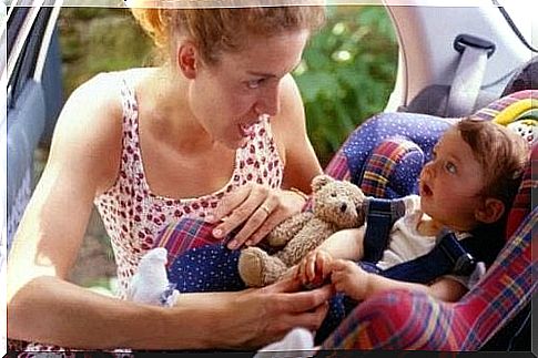 Mother with baby sitting in her car seat