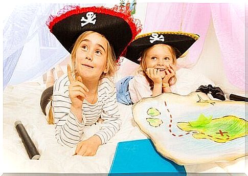 Girls dressed as pirates play treasure hunts as an example of developmental activities for kindergarten children