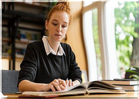 Girl reading book as part of distance learning