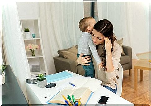 Mother with boy on her arm doing homework