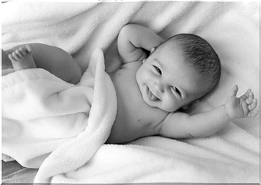 happy baby lying in a bed