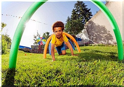 boy crawling under arches