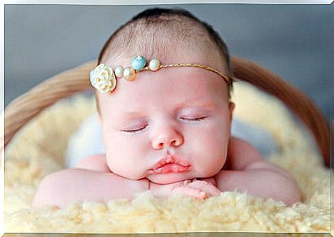 baby with thin pearl ribbon around his head