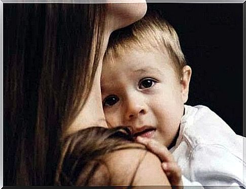 scared boy comforted by mother