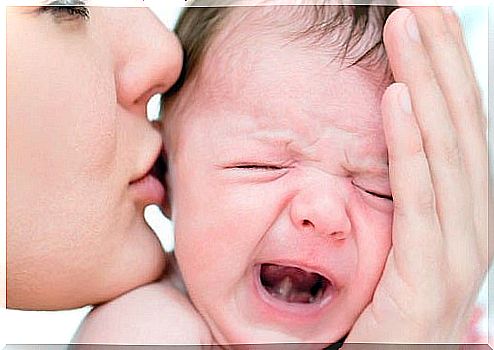 woman kissing crying baby