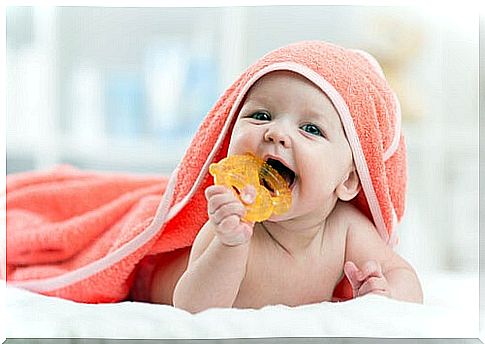 baby biting into rattle