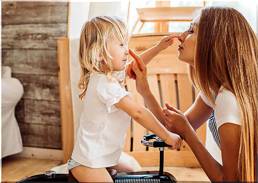 A mother and daughter touch each other's noses