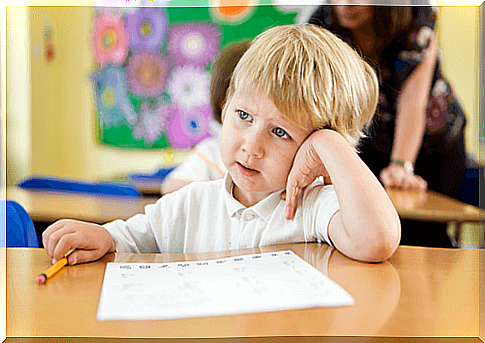 little boy at table in classroom at school