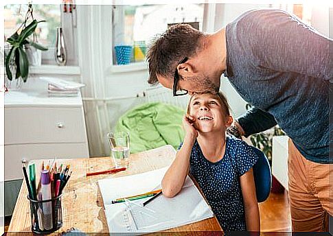 father kissing daughter on the forehead