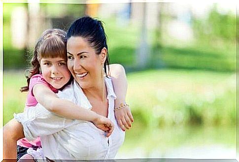 Smiling mother with daughter on back