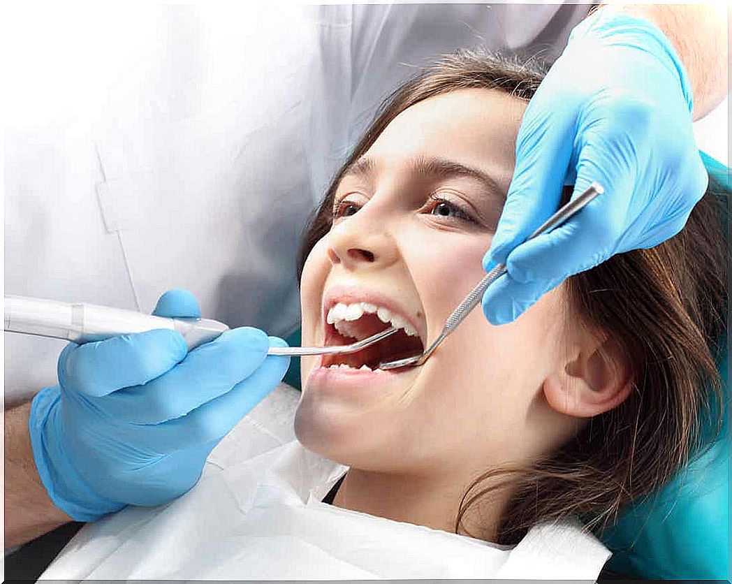 A dentist treats a young girl