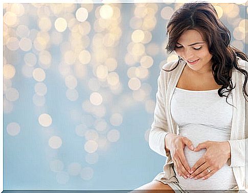 pregnant woman forming a heart on her belly