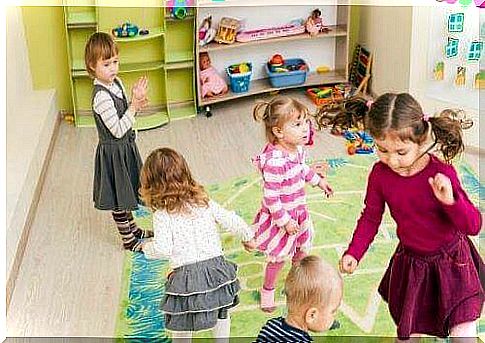 Teaching social skills: Children dance together in kindergarten.