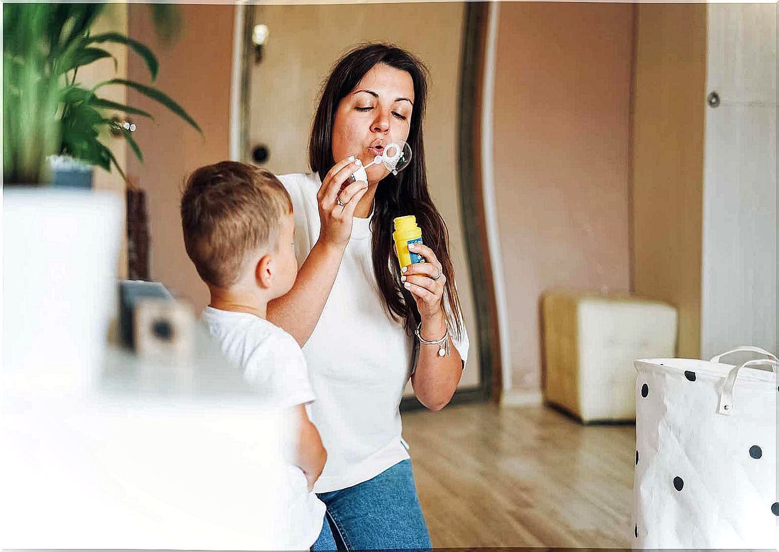 A mother blowing bubbles with her little son