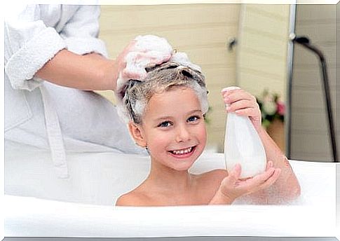 little girl getting her hair washed by her mother