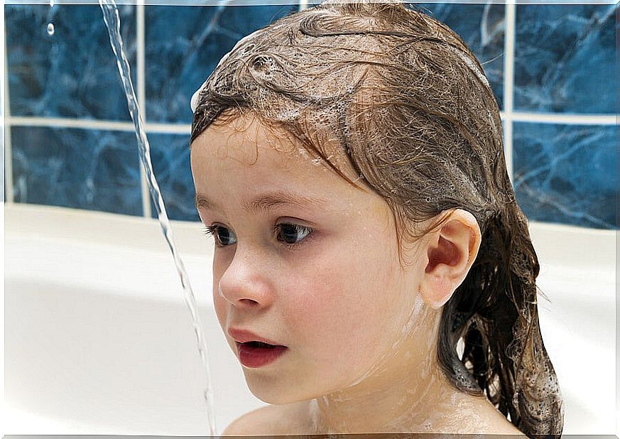 little girl in bath with soap in her hair