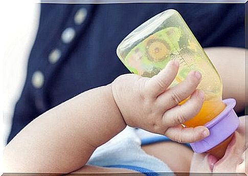 Baby drinks from baby bottle