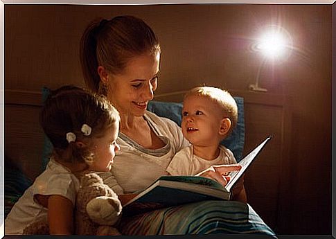 mother reading bedtime story to her two young children