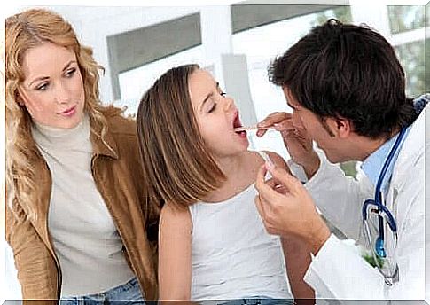 When to remove the tonsils in children.  Doctor checks girls' mouths and tonsils.