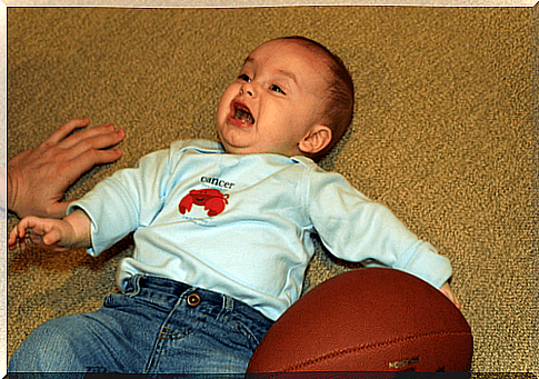 baby is lying on the floor crying after a fall