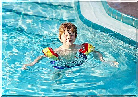 little boy bathing with mittens on